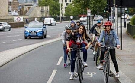Woman smiling on bike on cycle lane (cycle superhighway)