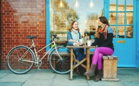 Women at cafe with bike, sitting having coffee