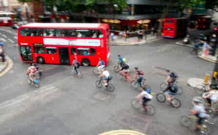 Group of people cycling through junction with bus